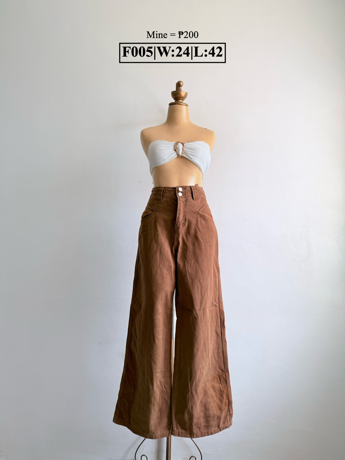 Brown wide-leg pants with double-button waistband on a mannequin